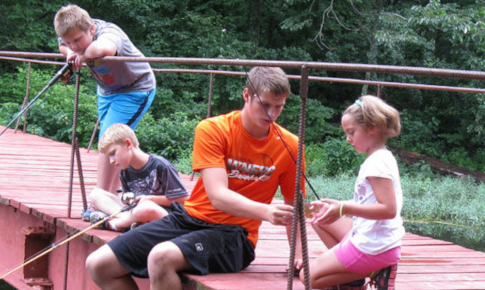 A Counselor and campers on the bridge at Camp Carew